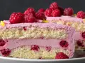 Pyszny tort z warstwami biszkoptu, przełożony kremem malinowym z mascarpone i świeżymi malinami.