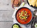 Prawdziwa zupa meksykańska z fasolą, kukurydzą i awokado, podana z nachos i serem.