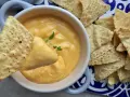 Chrupiące nachos zanurzane w kremowym, żółtym sosie belgijskim. Idealna przekąska na imprezę.