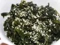 Sałatka z wodorostów wakame, posypana sezamem. To pyszne i zdrowe danie, które warto spróbować, jeśli zastanawiasz się, wakame co to.