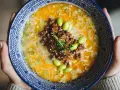 Miseczka tantanmen z mielonym mięsem, edamame i szczypiorkiem.