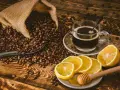 Aromatczna kawa z cytryną i miodem, otoczona ziarnami kawy wysypującymi się z worka.
