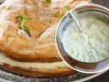 Jak uratować zwarzony krem z mascarpone? Na zdjęciu ciasto z kremem i garnek z masą, która może wymagać poprawy.