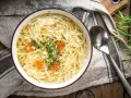 Miseczka domowego rosołu z makaronem i marchewką, posypana koperkiem. Idealny na lekki posiłek, niskokaloryczny rosół kcal.