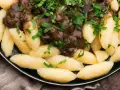 Kopytka z gulaszem, jak u babci! Pyszne ciasto na kopytka przepis babci, polane aromatycznym sosem i posypane natką pietruszki.