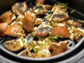 Pyszne pieczarki z airfryer, przyprawione i posypane natką pietruszki, gotowe do podania.