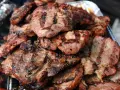 Soczysta karkówka z grilla, idealna po marynacie. Grillowane plastry mięsa z charakterystycznymi paskami.