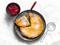 Puszysty omlet z air fryera, posypany cukrem pudrem, podany z żurawiną. Idealny na śniadanie.
