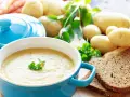 Aksamitna zupa ziemniaczana, przepis babci, z chlebem i świeżymi ziemniakami w tle.