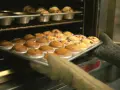 Rękawice wyjmują z piekarnika blachę z gotowymi muffinkami, które idealnie nadają się do przepisu na wilgotne i puszyste muffinki.