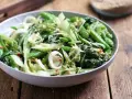 Sałatka z pak choi, groszku cukrowego i cebuli dymki, posypana sezamem. Idealna do dań kuchni azjatyckiej, świetne przepisy na kapustę pak choi.