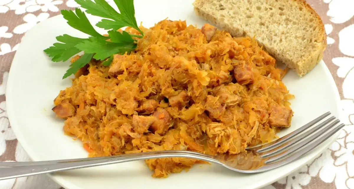 Tradycyjny polski bigos przepisy mistrzów. Aromatyczny gulasz z kapusty i mięsa, podany z chlebem i natką pietruszki.