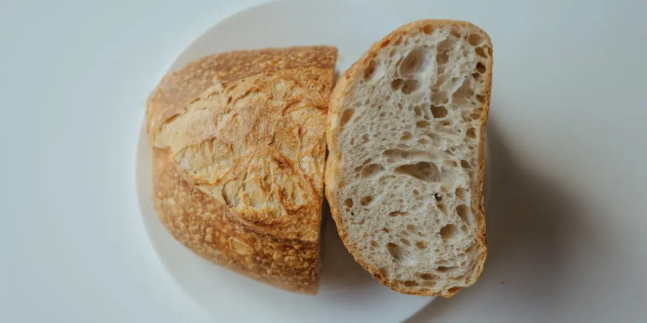 Chleb na talerzu, przekrojony na pół. Idealny przepis na szybki chleb, z chrupiącą skórką i puszystym wnętrzem.