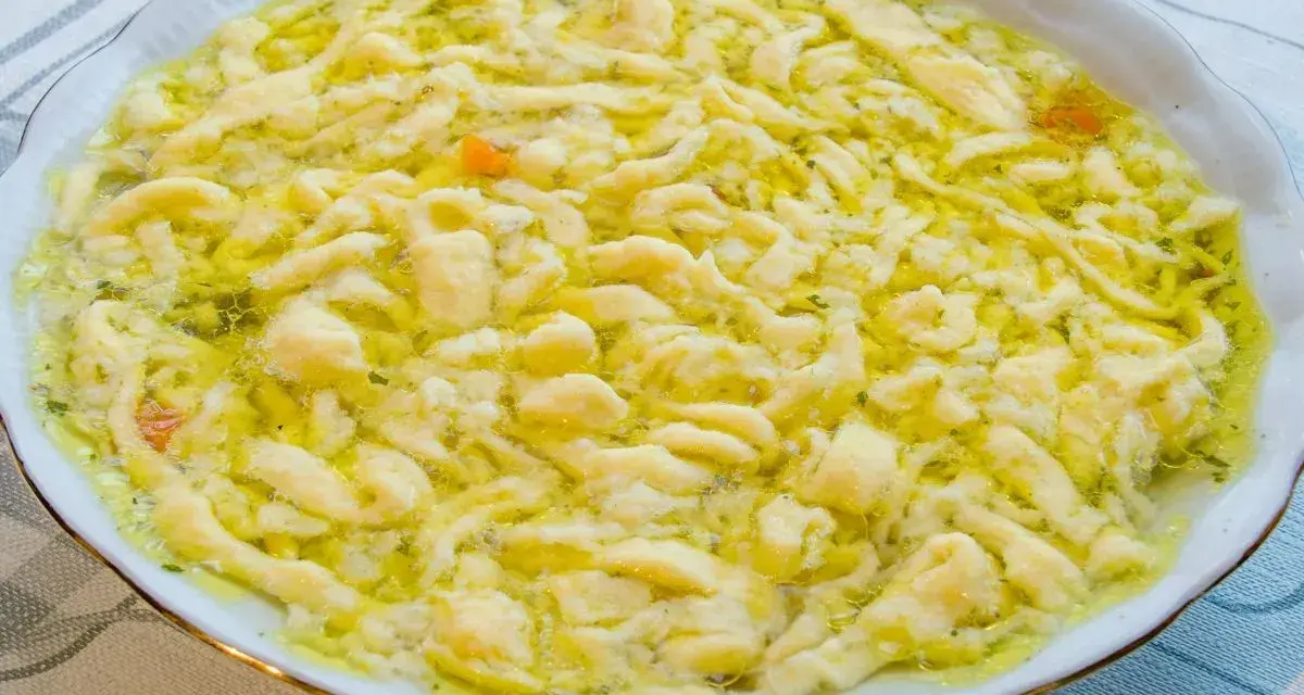 Pyszne lanki w bulionie, z widocznymi kawałkami marchewki i zieleniną.