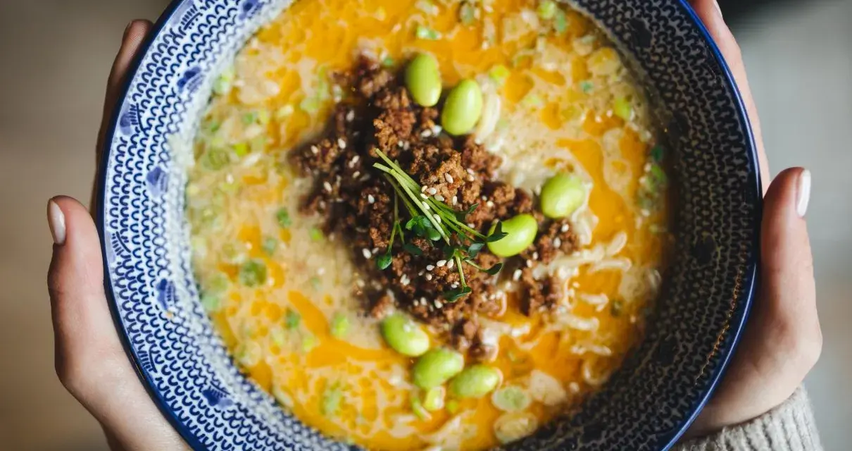 Miseczka tantanmen z mielonym mięsem, edamame i szczypiorkiem.