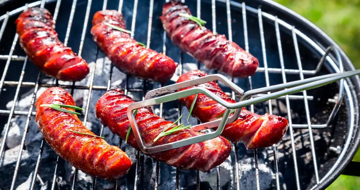 Soczysta kiełbasa na grilla, rumieniąca się nad żarem. Aromatyczny rozmaryn dodaje jej wyjątkowego smaku.