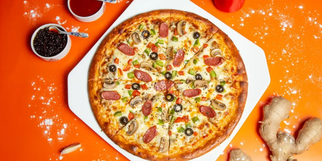 Pyszna pizza z kiełbasą, pieczarkami i papryką, obok sosy i imbir. Idealne dodatki do pizzy.