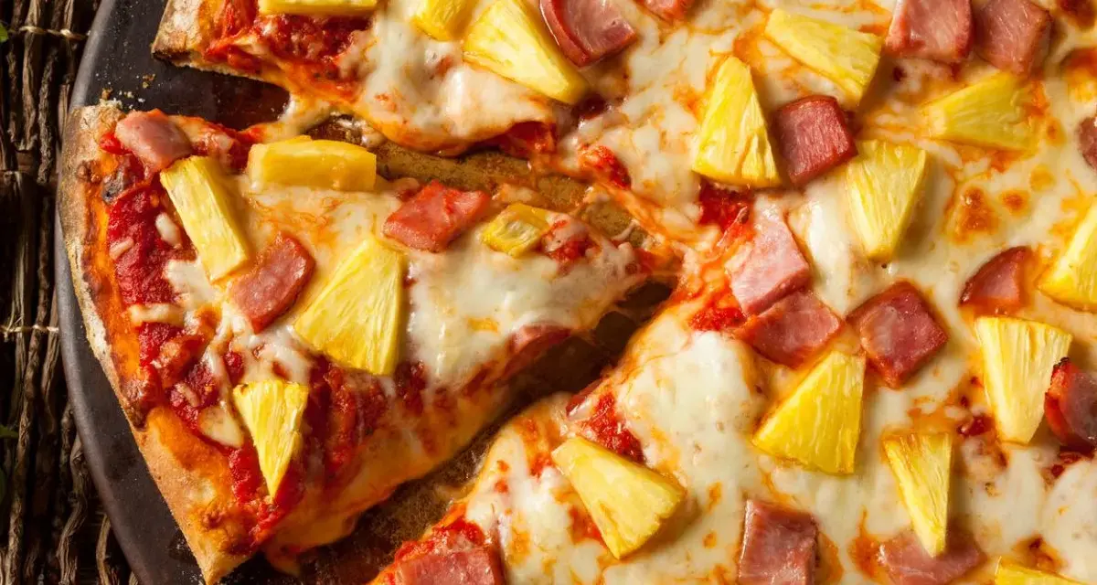Pyszna pizza z ananasem i szynką, z ciągnącym się serem i chrupiącym ciastem. Idealna na szybki obiad.