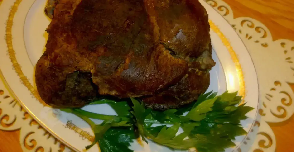 Apetyczna dziczyzna, pieczona do perfekcji, podana na eleganckim talerzu z gałązką natki pietruszki.