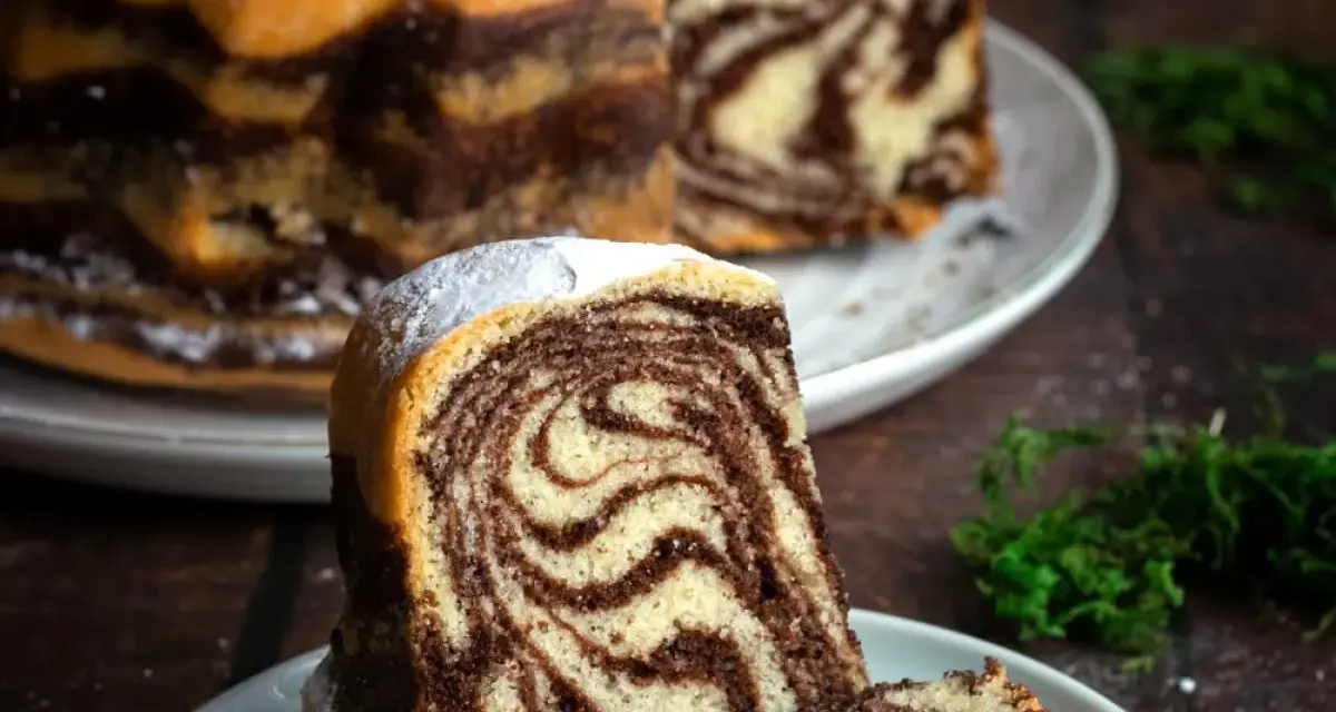 Wilgotne ciasto zebra z pięknymi wzorami, posypane cukrem pudrem. Idealne na deser.