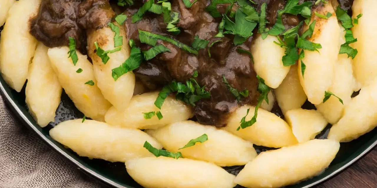 Kopytka z gulaszem, jak u babci! Pyszne ciasto na kopytka przepis babci, polane aromatycznym sosem i posypane natką pietruszki.