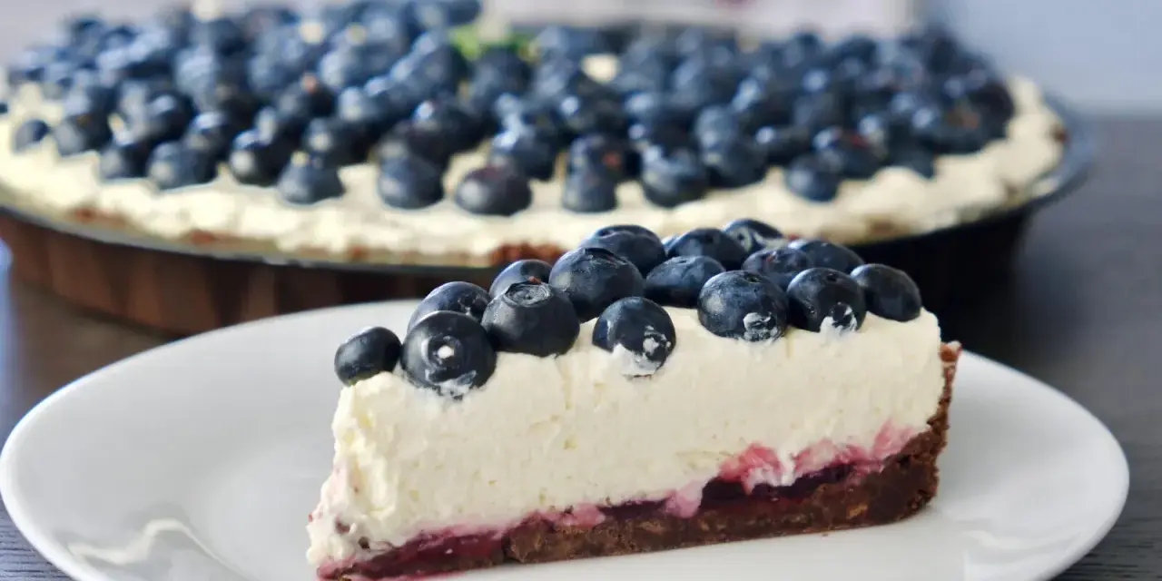 Pyszne ciasto z serkiem mascarpone pieczone, obficie udekorowane świeżymi borówkami. Idealne na deser.