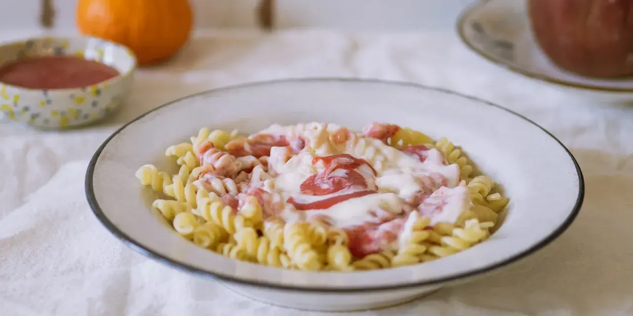 Fusilli z kremowym sosem i kawałkami owoców. Pyszny makaron na słodko, idealny na deser.