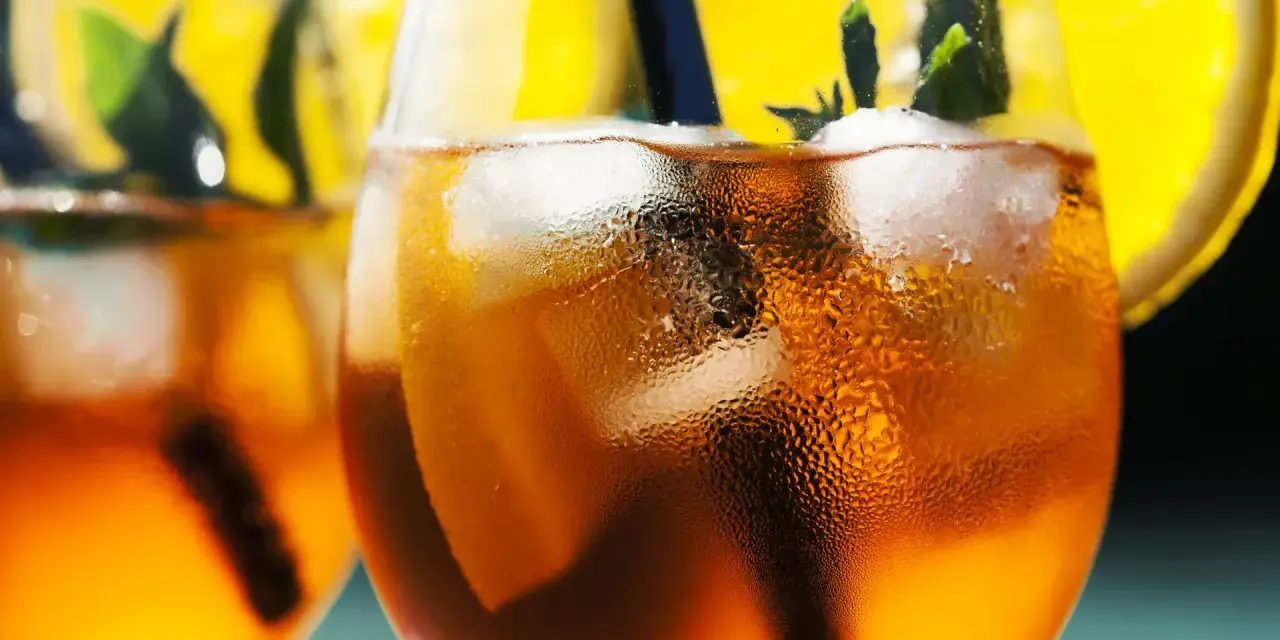 Orzeźwiający aperol bezalkoholowy z lodem, plasterkiem pomarańczy i miętą. Idealny na upalne dni.