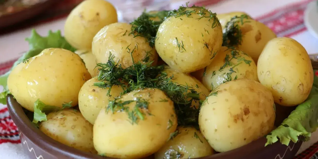 Młode ziemniaki z koperkiem, podane w glinianej misie. Czy ziemniaki tuczą? Zależy jak je przygotujesz!