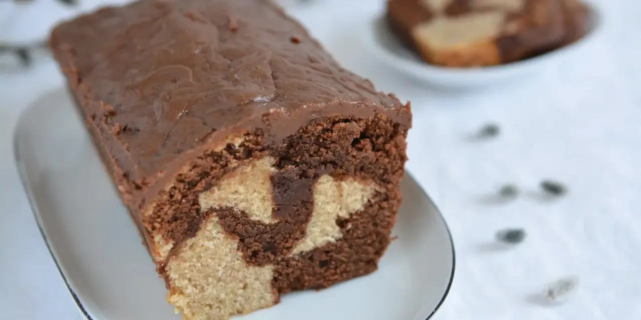 Wilgotna babka marmurkowa na oleju, z czekoladową polewą, prezentuje się apetycznie.