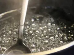 Gotowy syrop cukrowy w trakcie gotowania. Bąbelki unoszą się na powierzchni, a łyżka sprawdza konsystencję. Idealny przepis na domowy syrop.
