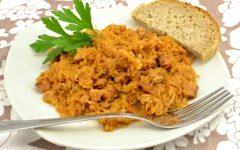 Tradycyjny polski bigos przepisy mistrzów. Aromatyczny gulasz z kapusty i mięsa, podany z chlebem i natką pietruszki.