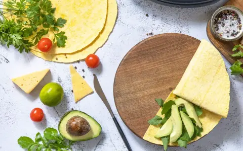 Składniki do keto tortilli: awokado, pomidorki, ser, limonka, rukola i przyprawy. Idealny keto tortilla przepis.