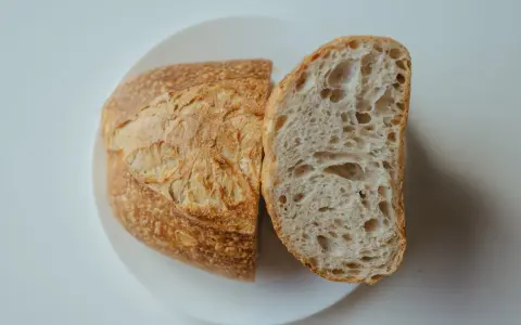 Chleb na talerzu, przekrojony na pół. Idealny przepis na szybki chleb, z chrupiącą skórką i puszystym wnętrzem.