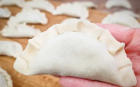 Gotowe do lepienia pierogi na desce. Idealne ciasto na pierogi, jak u Magdy Gessler, czeka na nadzienie.
