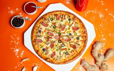 Pyszna pizza z kiełbasą, pieczarkami i papryką, obok sosy i imbir. Idealne dodatki do pizzy.