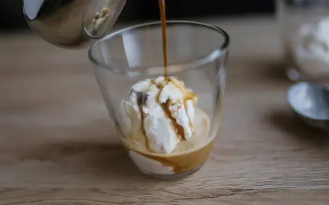 Gorące espresso zalewa gałkę lodów waniliowych, tworząc pyszne affogato.