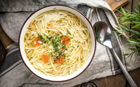 Miseczka domowego rosołu z makaronem i marchewką, posypana koperkiem. Idealny na lekki posiłek, niskokaloryczny rosół kcal.