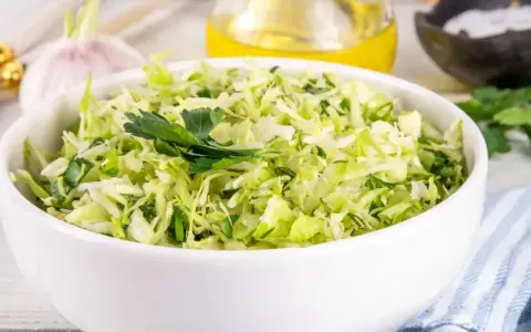 Sałatka z kapusty z czosnkiem i ziołami, idealna jako dodatek do obiadu. Cząber do czego? Do takich właśnie świeżych, aromatycznych sałatek!