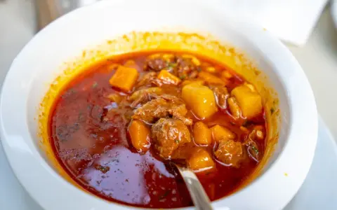 Aksamitna, aromatyczna, najlepsza zupa gulaszowa z kawałkami mięsa i ziemniaków w głębokim, czerwonym sosie.