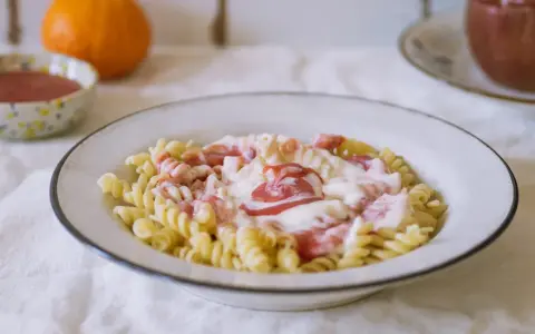 Fusilli z kremowym sosem i kawałkami owoców. Pyszny makaron na słodko, idealny na deser.
