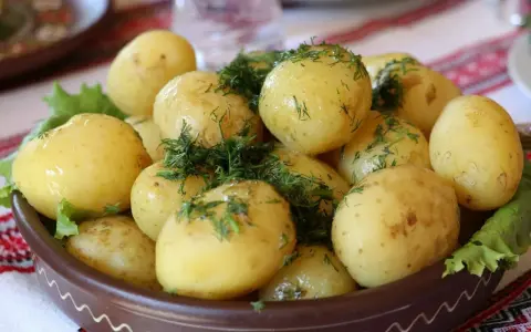 Młode ziemniaki z koperkiem, podane w glinianej misie. Czy ziemniaki tuczą? Zależy jak je przygotujesz!