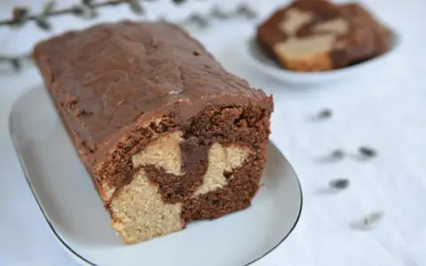 Wilgotna babka marmurkowa na oleju, z czekoladową polewą, prezentuje się apetycznie.
