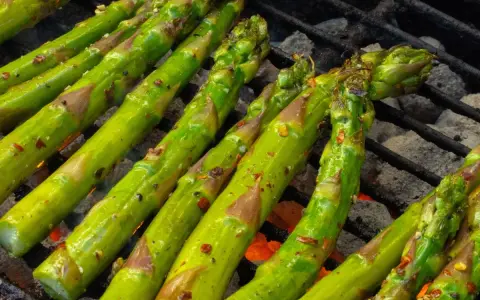 Zielone szparagi z grilla, przyprawione i lekko przypieczone, kuszą aromatem.