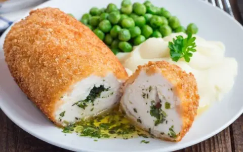 Idealne niedzielny obiad dla gości przepisy: panierowany kotlet z kurczaka z zielonym farszem, puree ziemniaczane i groszek.
