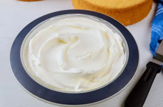 Puszysta bita śmietana z mascarpone w misce, gotowa do dekorowania biszkoptów.