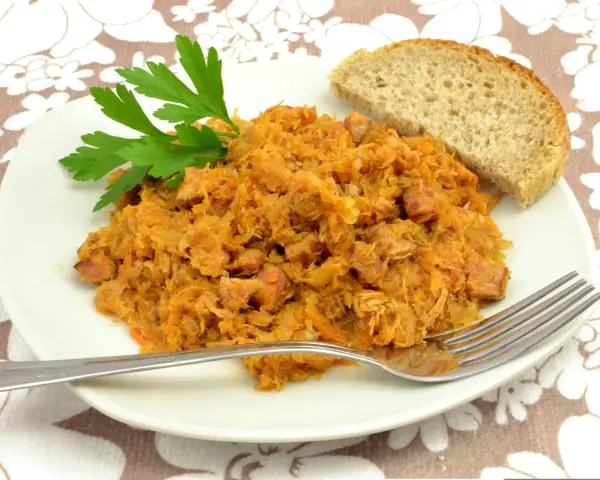 Tradycyjny polski bigos przepisy mistrzów. Aromatyczny gulasz z kapusty i mięsa, podany z chlebem i natką pietruszki.