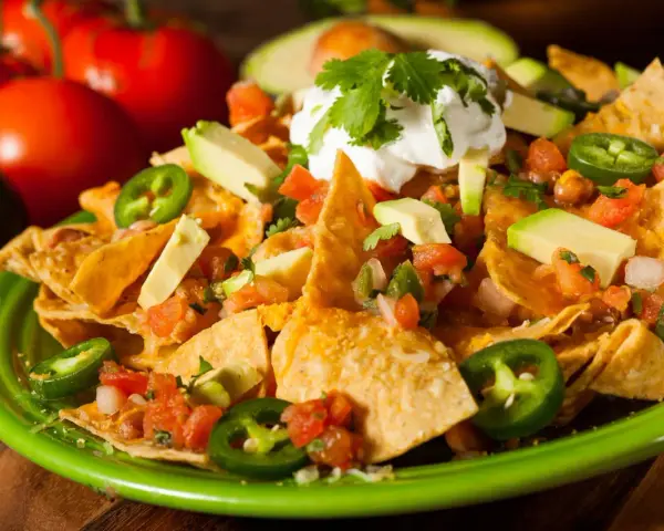 Nachos z serem, awokado, pomidorami i jalapeño. Idealna przyprawa meksykańska na imprezę.