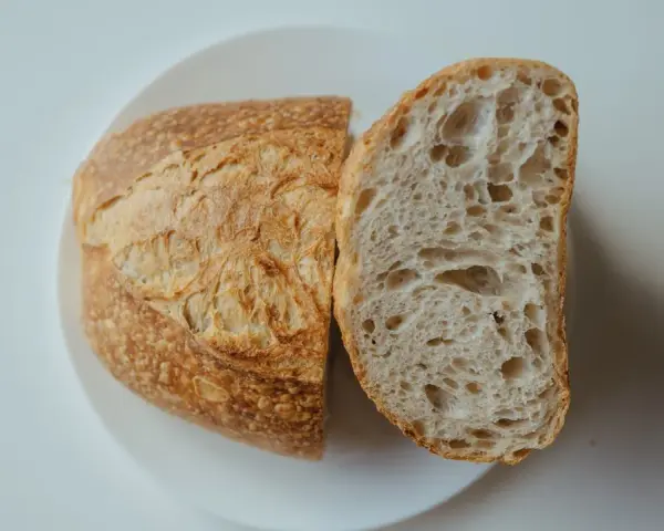 Chleb na talerzu, przekrojony na pół. Idealny przepis na szybki chleb, z chrupiącą skórką i puszystym wnętrzem.