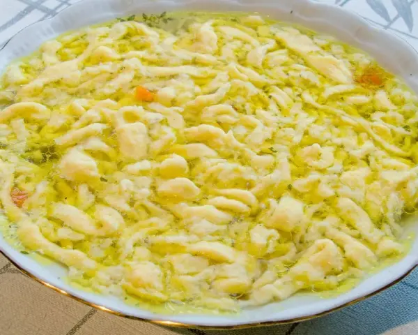 Pyszne lanki w bulionie, z widocznymi kawałkami marchewki i zieleniną.